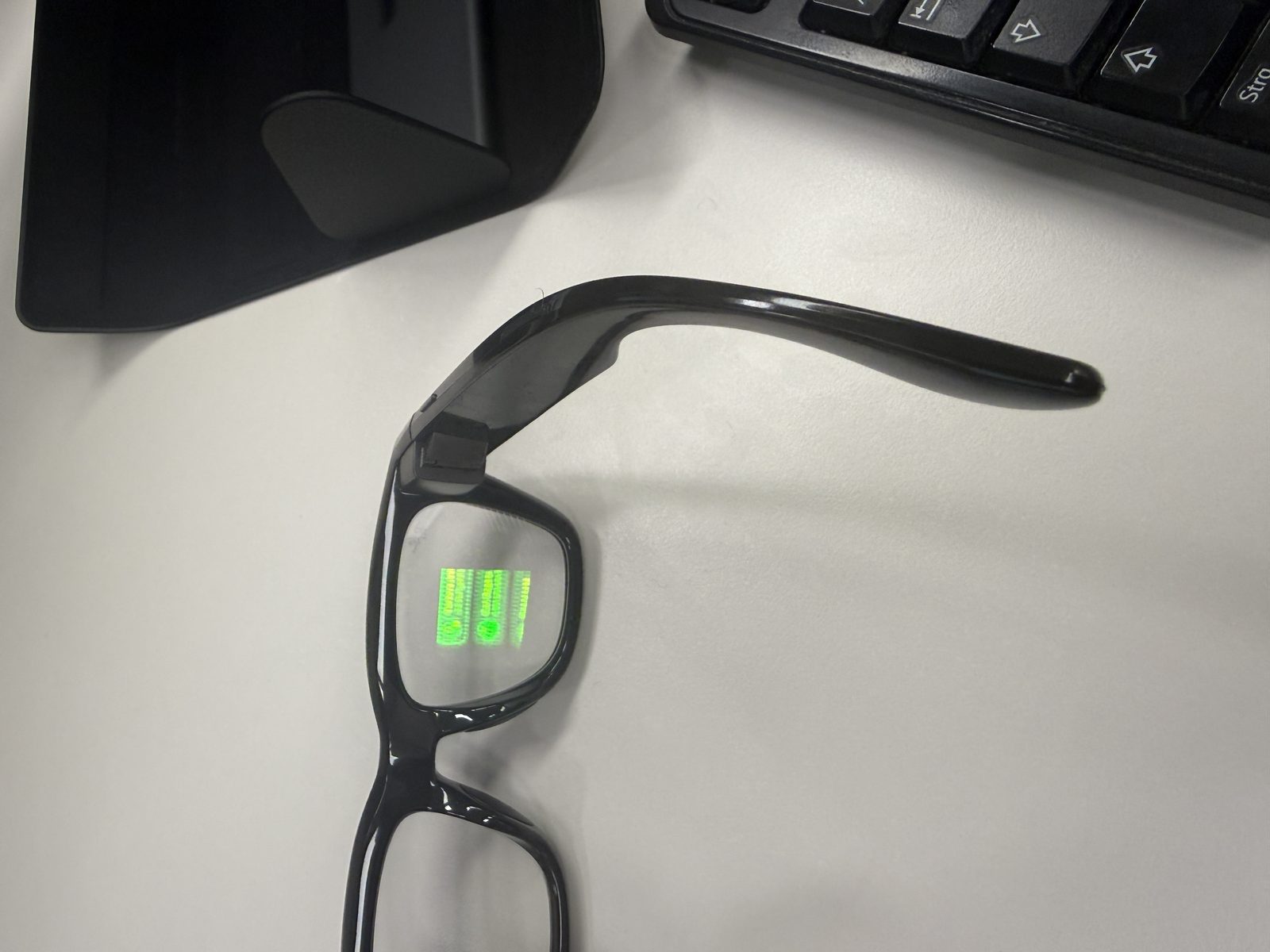 Nahaufnahme des rechten Brillenglases mit sichtbarem grünem Farbdisplay