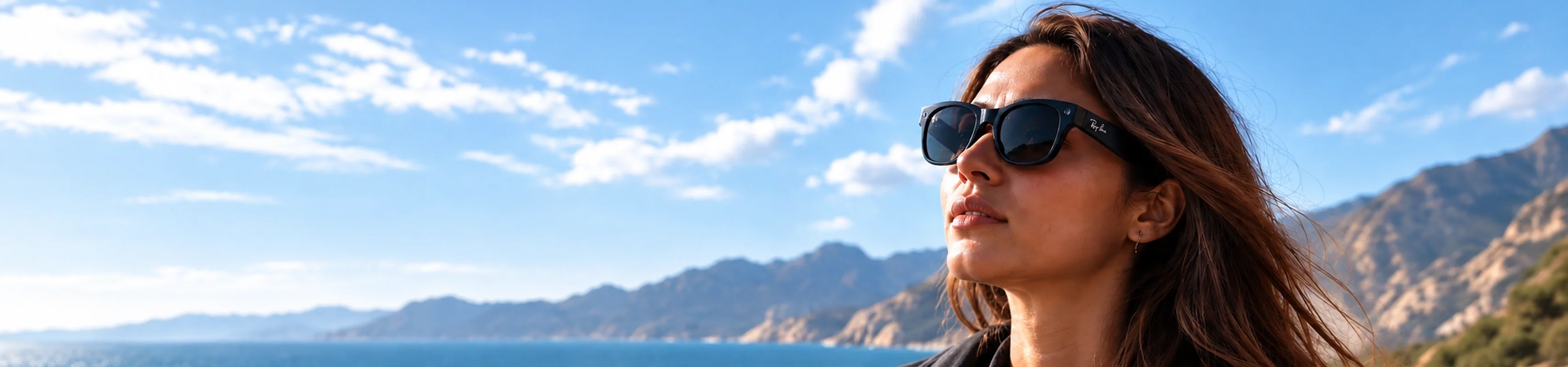Frau mit Ray-Ban Meta Smart Glasses vor Küstenhintergrund